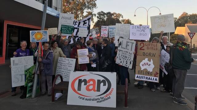 Showing support: Refugee advocates gather outside Helen Haines' office in Wangaratta on Tuesday night to display their support for Sri Lankan couple Nadesalingam and Priya and their daughters Kopika and Tharunicca. 