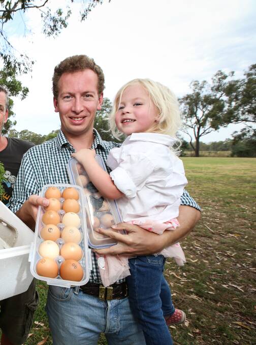Having a crack: Tobias Lehmann and his daughter Violet with some of the eggs that are sold at markets after being laid at his Walla farm.