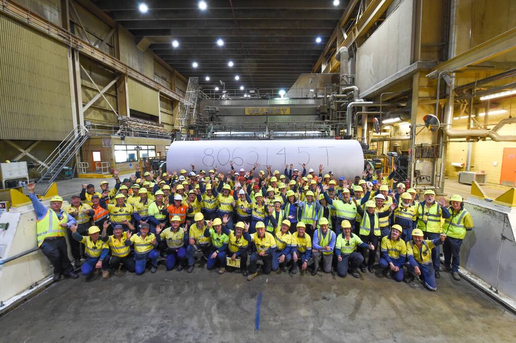 Milestone: Mill workers and contractors mark the final roll on Thursday with an arm pump to signify the achievements of the factory. Picture: MARK JESSER