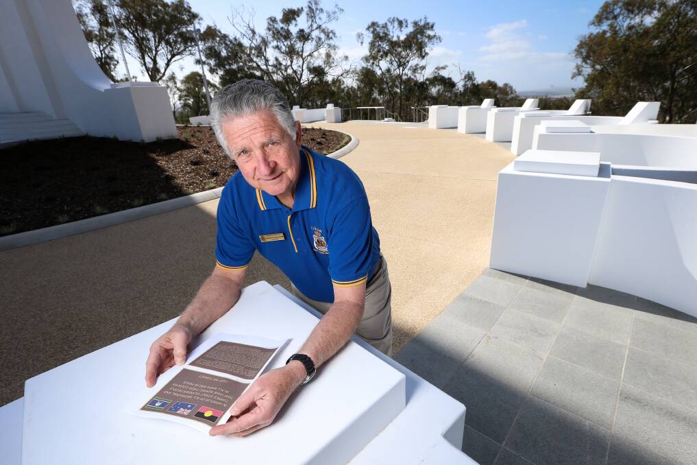 Wait and see: RSL sub-branch president Graham Docksey at the revamped Albury monument with images of how plaques being shipped from China to complete the upgrade will appear. They will be fitted to the new alcoves in the background. Picture: JAMES WILTSHIRE