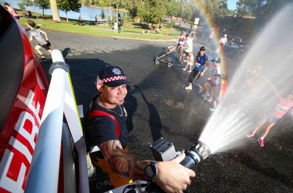Cool job: West Wodonga CFA member Brent Jackson had the task of providing a refreshing spray of water to City2City entrants at Sumsion Gardens.