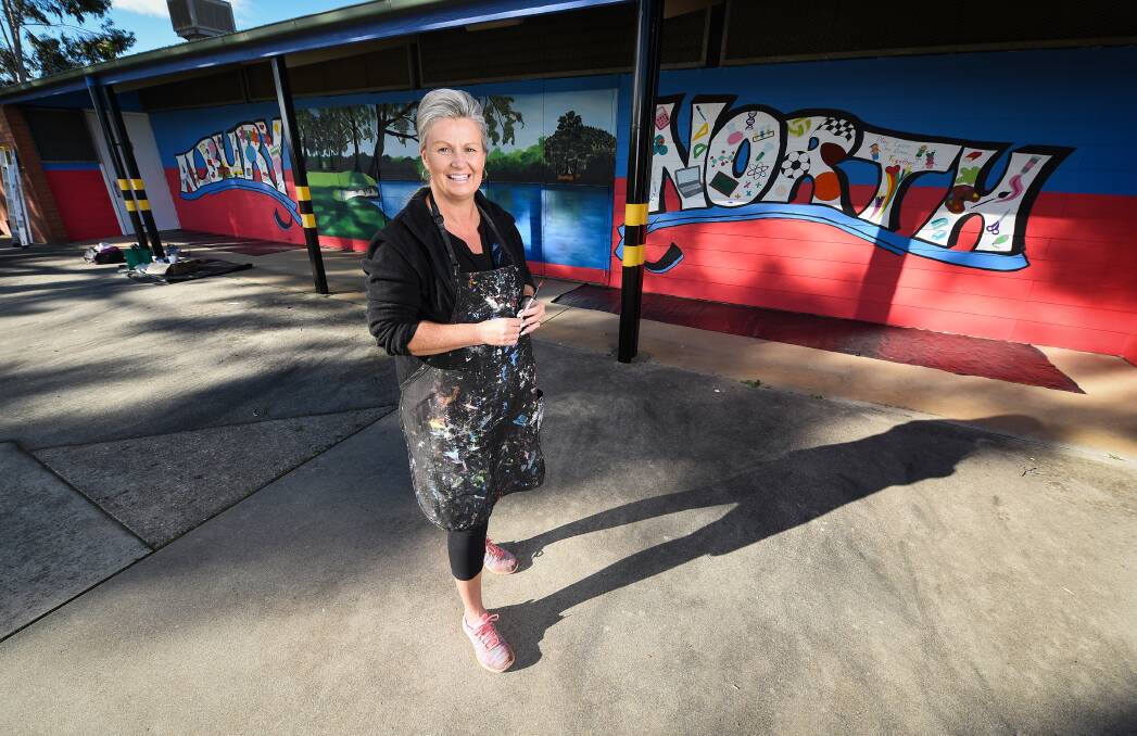 Layering of a different type: Hairdresser/artist Sharee Richardson in front of her mural at Albury North Public School which features an image of the trees overhanging the Murray River in the city. Picture: MARK JESSER 