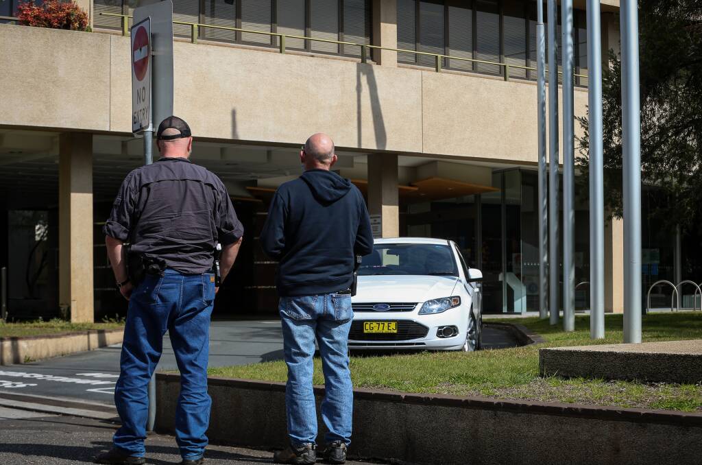 On patrol: Two plain clothes policemen monitor the exterior of the Albury Council offices following Tuesday morning's protest. Picture: JAMES WILTSHIRE