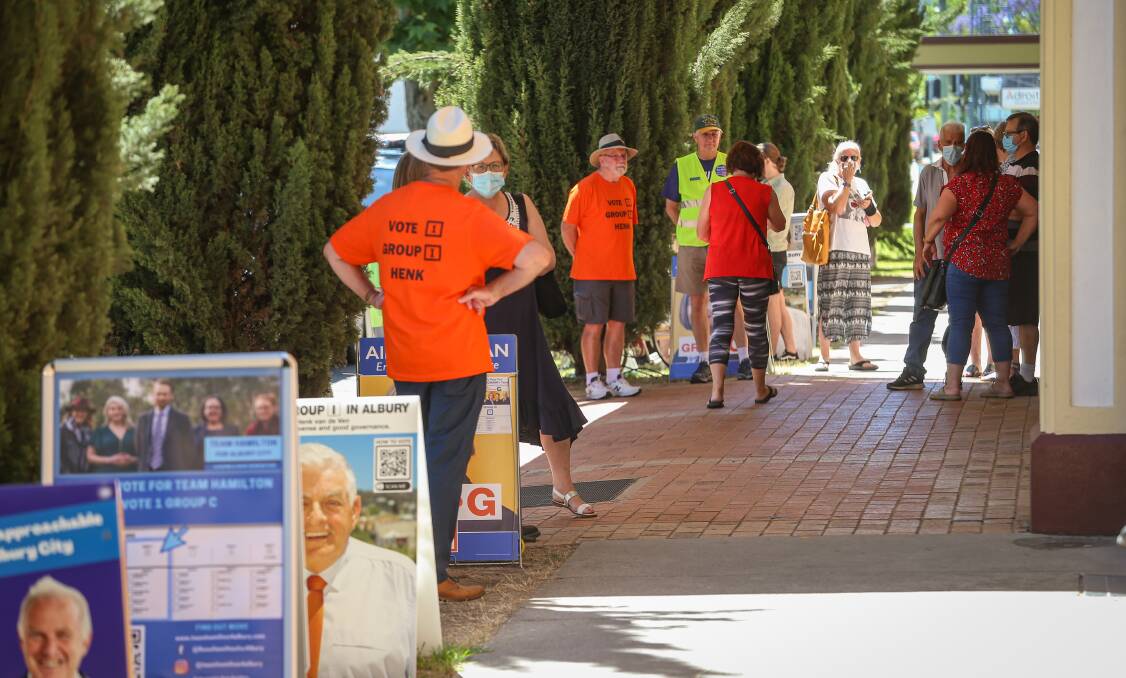 Last minute pitches: Orange-shirted supporters of councillor Henk van de Ven were outside the Smollett Street early voting station on Friday afternoon. Picture: JAMES WILTSHIRE