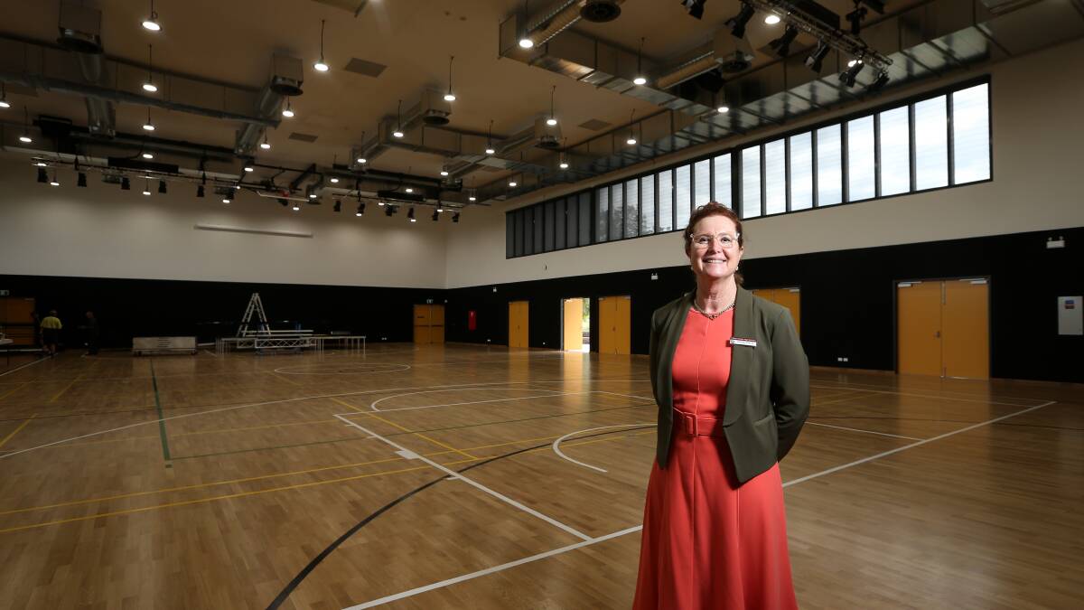 Delighted: James Fallon High School principal Jenny Parrett inside the new hall which can house up to 850 people in a sitting. The yellow doors represents the school's past colour. Picture: JAMES WILTSHIRE