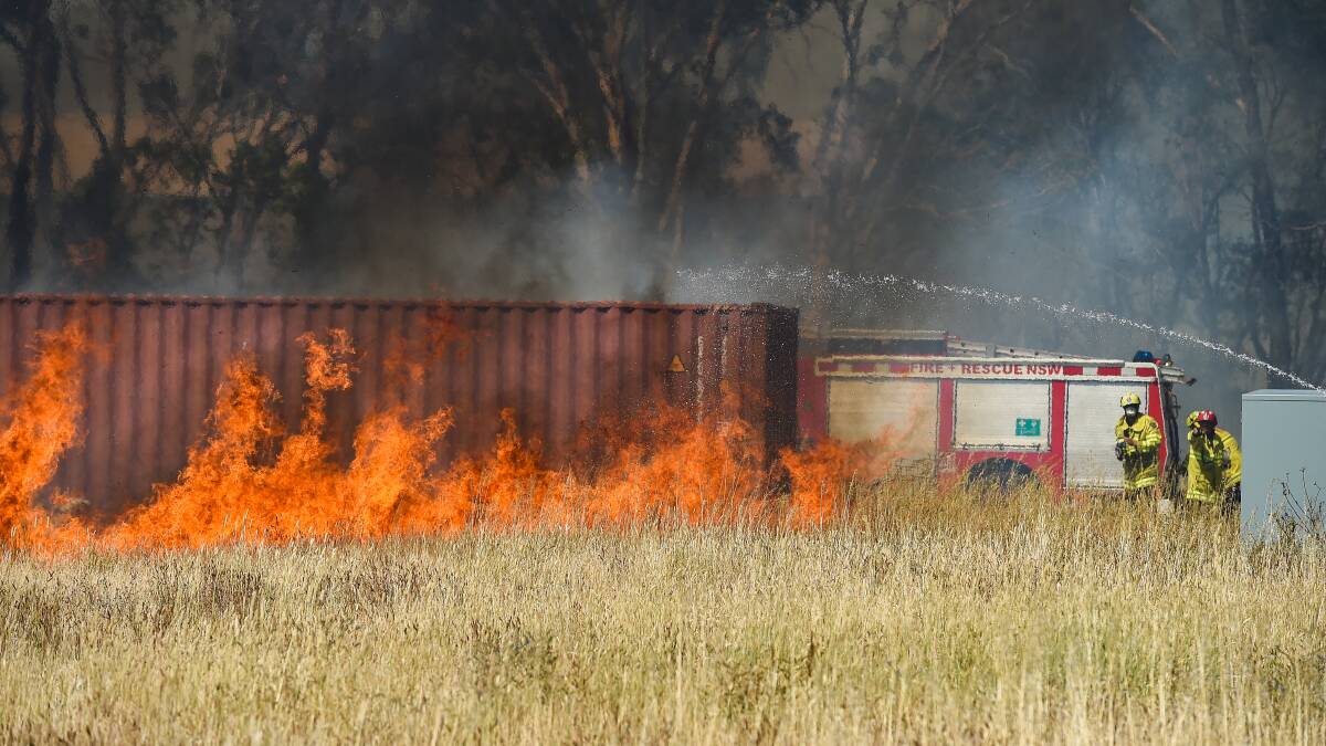 In action: Firefighters move in to stop flames threatening a storage container near Ceres Drive on Tuesday afternoon. Picture: MARK JESSER