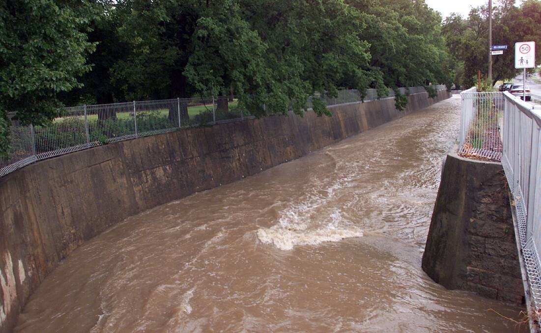 Wall to wall water: A torrent flows down Bungambrawatha Creek on the manmade section of the creeek next to the Albury botanic gardens in 2005.