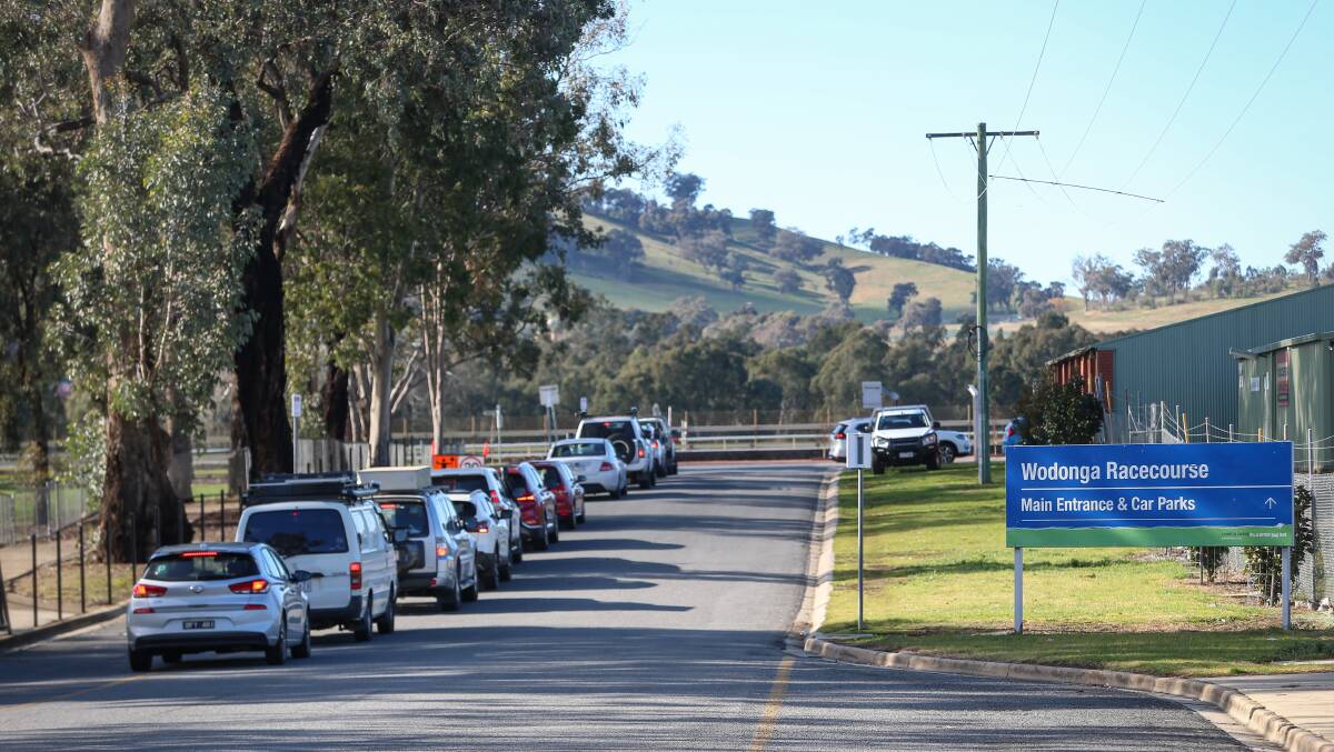 Lengthy wait: Cars line up to enter Wodonga racecourse on Tuesday following its opening for testing. Picture: JAMES WILTSHIRE