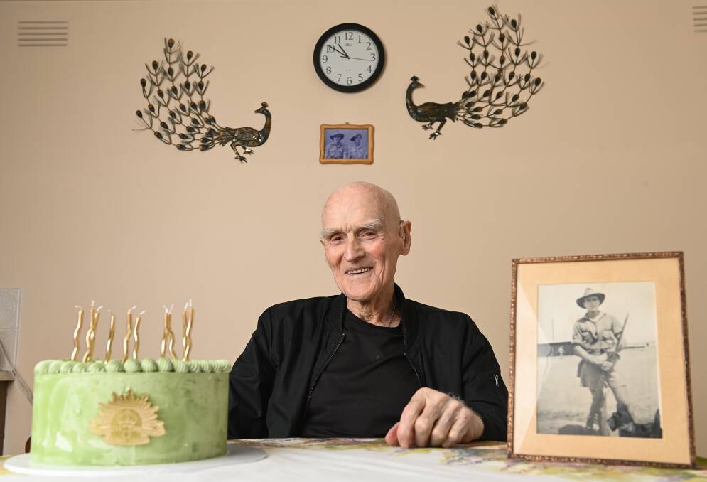 Milestone man: Jim Mooney with his birthday cake featuring the rising sun army insignia and a photo of him in Palestine during World War II. Picture: MARK JESSER