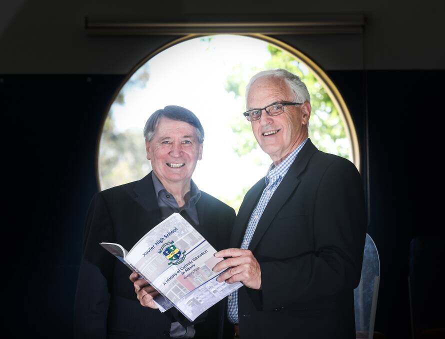 Window on history: Dennis Richardson and Greg Ryan with the latter's book detailing the history of Catholic education in Albury. Picture: KYLIE ESLER