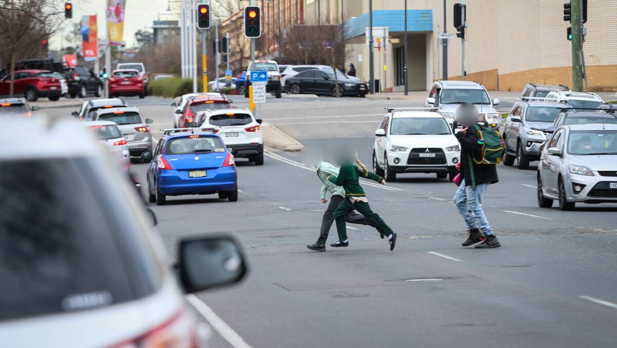 Making a dash: St Patrick's Parish School pupils traverse Kiewa Street with a carer after the bell on Thursday. Albury councillor Murray King wants a traffic island in the street to make it safer to cross. Picture: JAMES WILTSHIRE