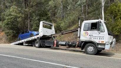 Taken away: A Volkswagen Golf is removed by tow truck after police pulled it over on the Tawonga Gap Road on Sunday afternoon. Picture: SUPPLIED