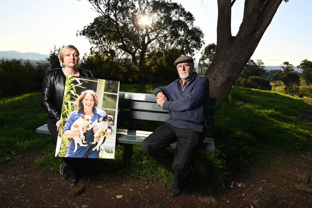 Lauren and Allan Black sit on the bench which has plaque dedicated to their mother and wife Elke, who is depicted in a photograph in 2015 on Lauren's wedding day with dogs Lolly and Alfie. Picture by Mark Jesser.