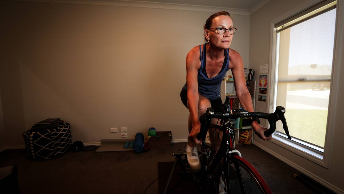 Eyes on the prize: Ange Ednie on her training bike which faces a wall filled with papers outlining her gradual goals to return to full fitness. Picture: JAMES WILTSHIRE