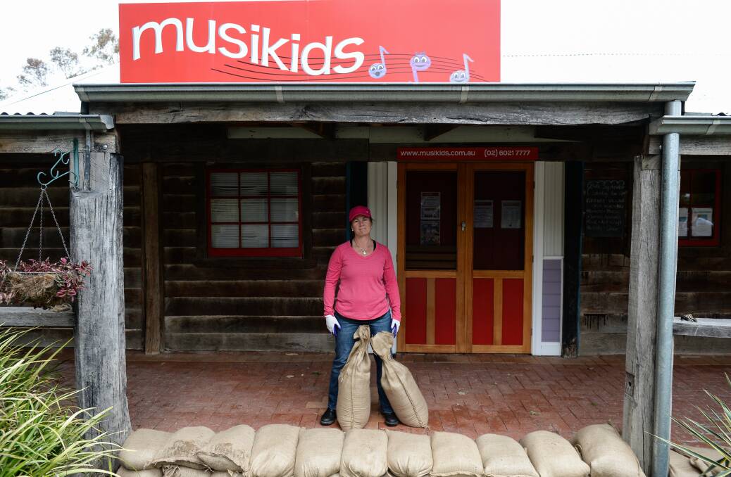 Protected: Musikids operator Kathryn Pyle places sandbags at her front verandah after water reached there on Wednesday morning. Pictures: MARK JESSER