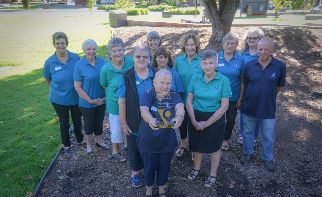 Proud crew: Erin Pascoe holds up the tourism award as her fellow Myrtleford Visitor Information Centre volunteers join in celebrating the recognition. Picture: ALPINE SHIRE