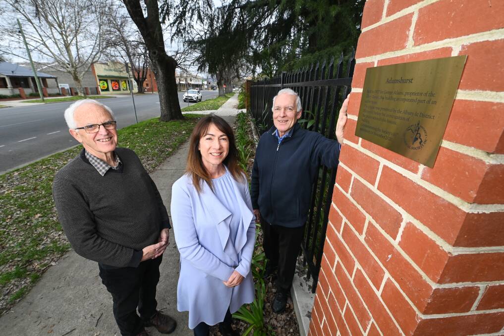 Stainless steel marker: Greg Ryan, Kylie King and historical society president Geoff Romero with the Melbourne-made plaque on a fence pillar outside Adamshurst in central Albury. Pictures: MARK JESSER