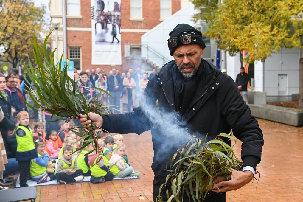 Wiradjuri descendant Darren Wighton conducts a smoking ceremony as preschoolers watch on with curiosity. Picture by Mark Jesser