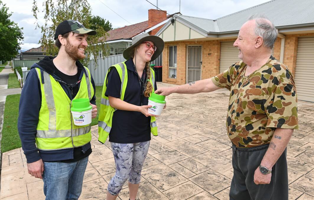 Lavington resident Frank Scott puts some money in a can being held by volunteer collector Lauren Sanders-Berg while her colleague Zachary Ryan watches on during last year's Good Friday Appeal.

