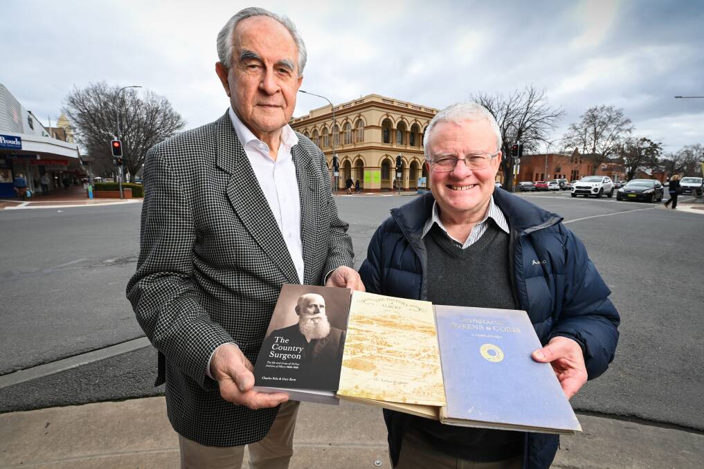 Biographers Charles Stitz and Gary Kent with their book alongside Arthur Andrews' works on Albury's history and Australia's coins. They are standing in front of the building which once housed Dr Andrews' coins when it was the town's museum. Picture by Mark Jesser