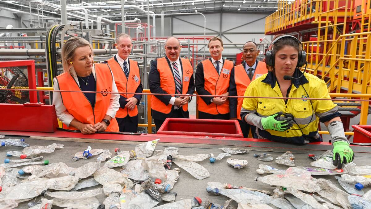 At work: Rhiannon John removes imperfect bottles as Sussan Ley, Coca-Cola chief Peter West, Robert Iervasi, James Griffin and Pact Group boss Sanjay Dayal watch on before the PET is remade. Picture: MARK JESSER