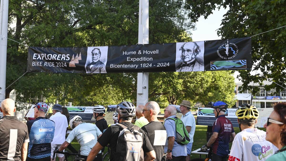 The faces of Hamilton Hume and William Hovell look over the launch from a banner made for the event. The gum leaf design of Mick Bogie can be seen in the far right corner below the historical society's logo. Picture by Mark Jesser