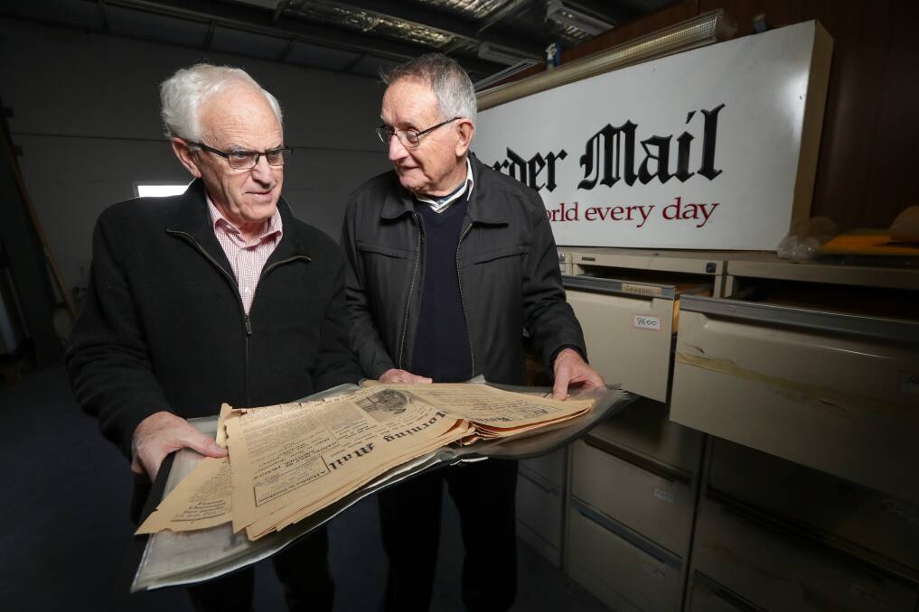 A glimpse of the past: Greg Ryan and Bruce Pennay examine a copy of The Border Morning Mail from July 1, 1939, which reported on tensions escalating between Britain and Germany in the lead-up to what became World War II. Picture: JAMES WILTSHIRE