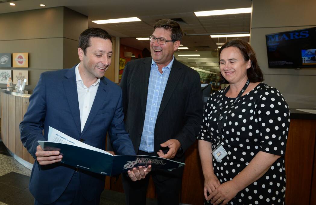 Number crunching: Matthew Guy and Bill Tilley with Mars Petcare's Penny Campbell and a brochure outlining the Liberal Party's population and decentralisation policy. Picture: MARK JESSER