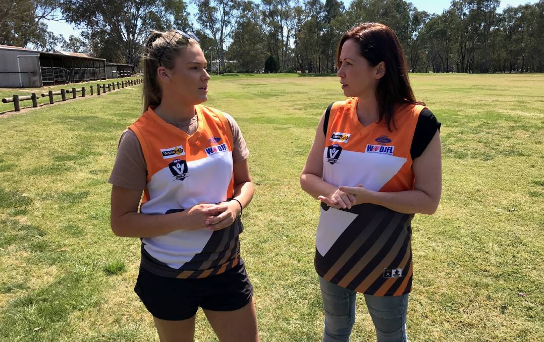 Welcome move: Becky Webster and Jaclyn Symes in Benalla junior football club jumpers at the announcement of change room funding.