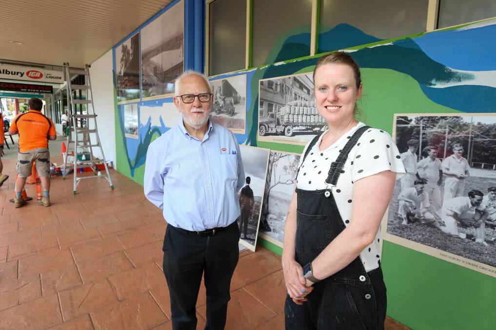 History on show: East Albury supermarket owner Bob Mathews and graphic designer Lisa Goff in front of the new mural on Tuesday as 13 historic photographs were being installed. Picture: JAMES WILTSHIRE