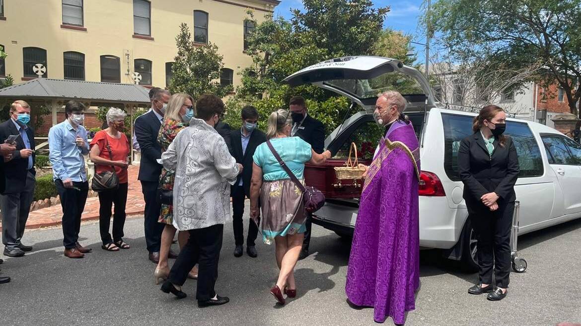 Farewell to a leader: Mourners place sprigs of rosemary on Les Langford's casket under the guidance of Father Peter MacLeod-Miller following a funeral for the former mayor at St Matthew's Church on Tuesday.