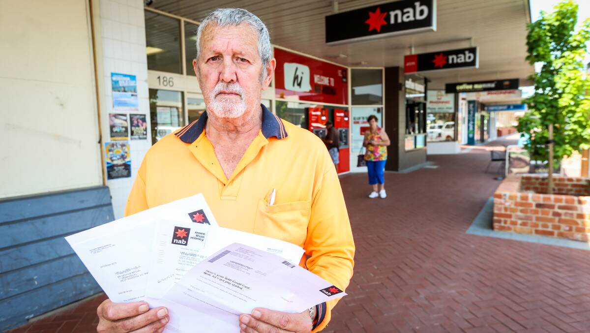 Horrified: Graham Brown outside Wodonga's NAB branch with the letters sent to him stating he had an account and credit card with the bank. Picture: JAMES WILTSHIRE