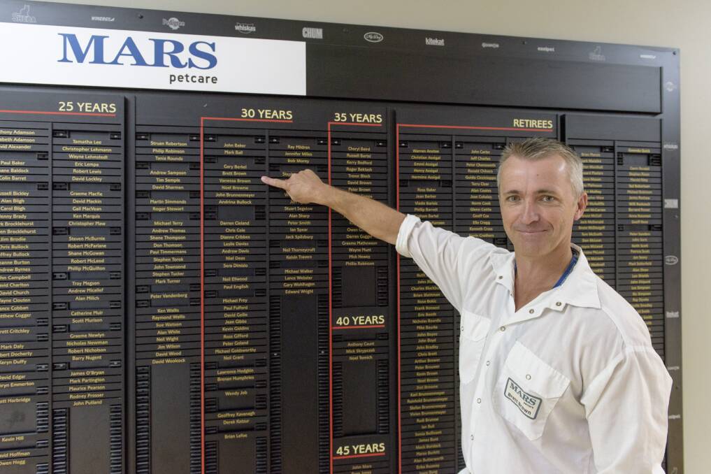 Etched in history: Veteran Mars worker Brett Brown points to his name on a board for those who have worked at the site for 10 years or more, be they current or retired.