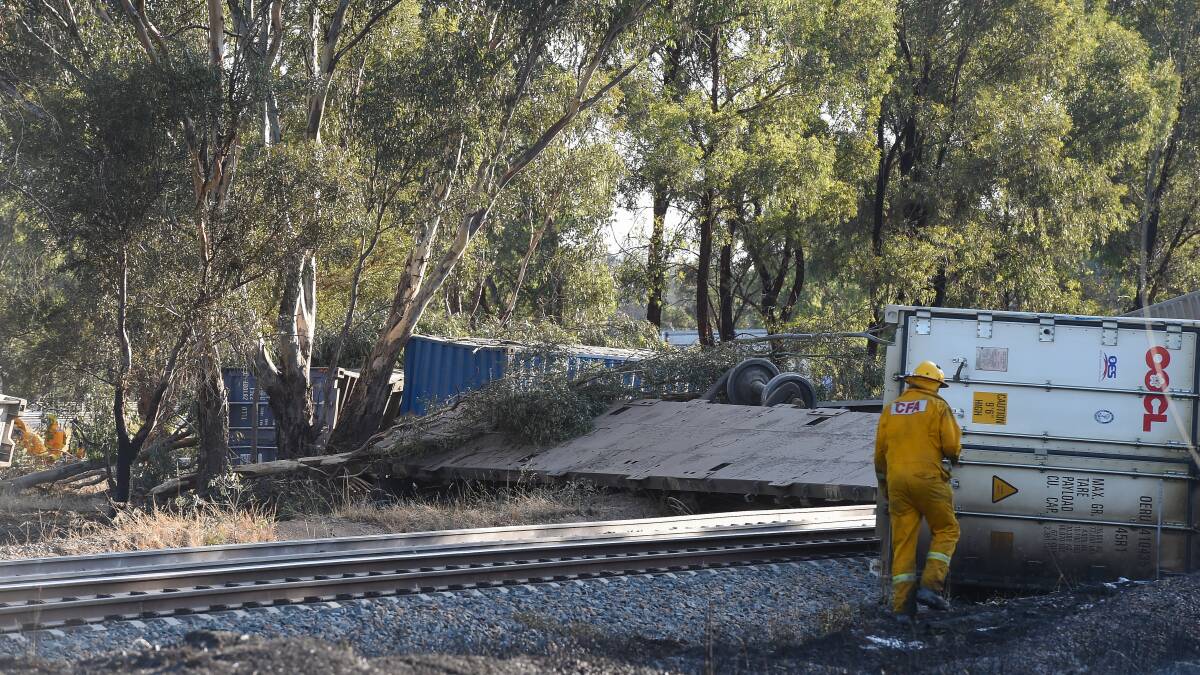 Big mess: A flat-bed wagon is at right angles to the train line and containers are strewn across the landscape after the derailing. Fires were sparked but quickly halted. Picture: MARK JESSER