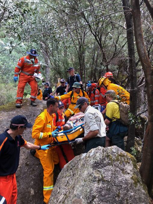 Tricky journey: Emergency workers carry a man who fell down Eurobin Falls out to a car park before he was taken by ambulance to a helicopter for a flight to Melbourne. Picture: BRIGHT SES