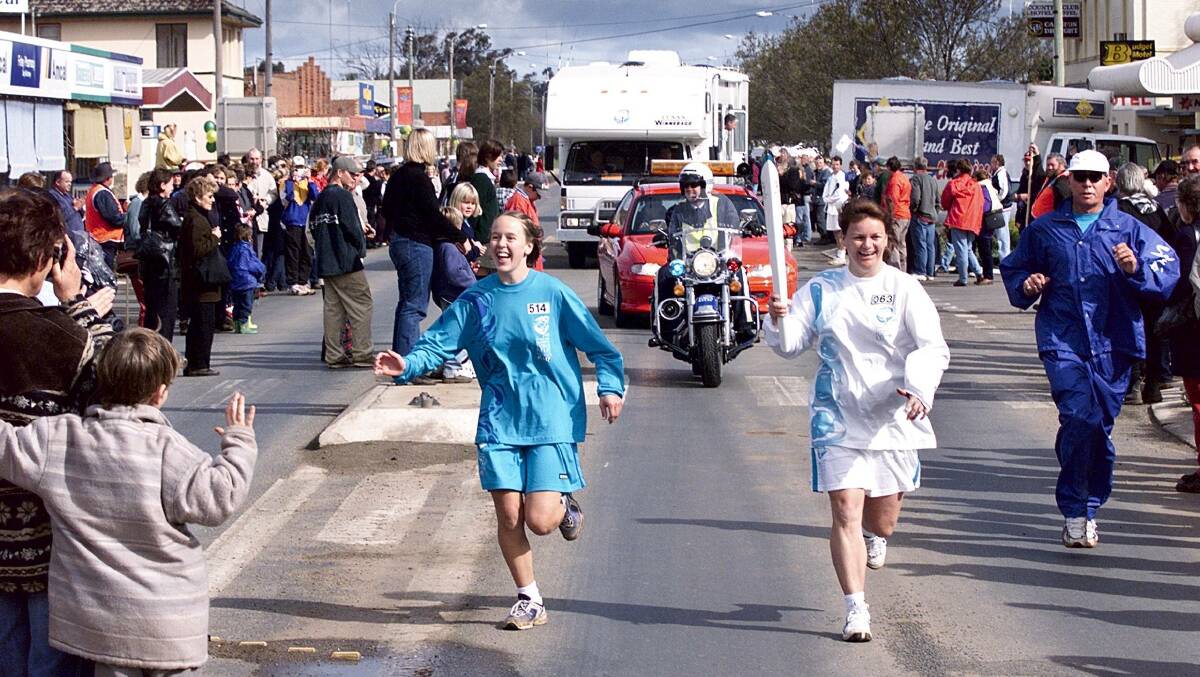 LIVING IT UP: Jenny Wilson holds the torch aloft as she runs through Finley during the relay. She was among scores of participants photographed by Border Mail lensman Matthew Smithwick.
