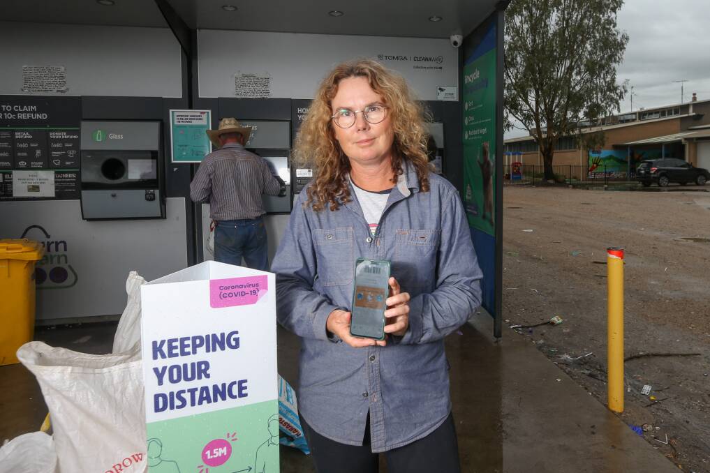 New approach: Recycler Gen Quinn used a mobile phone app to avoid touching the screen on the container machine at East Albury on Thursday. Picture: TARA TREWHELLA