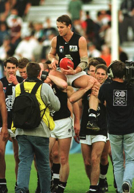 Glory days: Peter Dean is chaired off the ground after a milestone match against Port Adelaide at Football Park in 1998. At the time one of his team-mates was Adrian Whitehead who later worked alongside him as a coach in the Upper Murray.