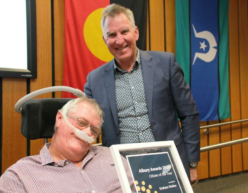 Acknowledgment: Graham Walker is formally presented with his Citizen of the Year citation by Albury mayor Kevin Mack at a council meeting last month. Mr Walker was unable to attend the Australia Day ceremony because he had booked tickets to the Australian Open tennis thinking he had no chance of receiving the gong. Picture: ALBURY CITY