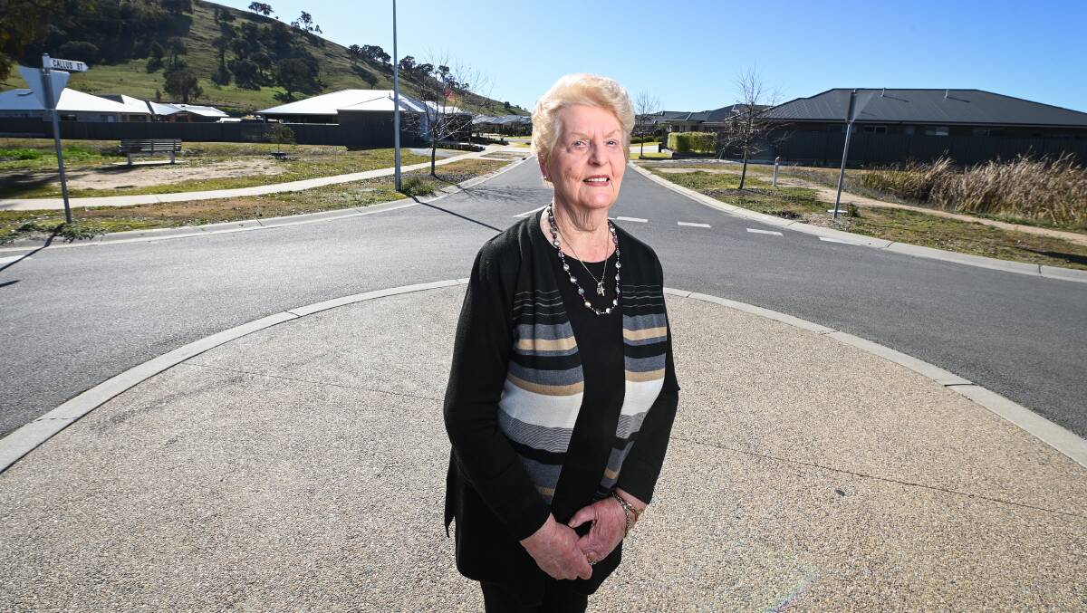 Delighted daughter: Pat Corcoran stands on a roundabout in front of two areas of greenery which will be named for her parents Stella and Archie Nugent. They are located on either side of Callus Street, Killara, which is in the background Picture: MARK JESSER
