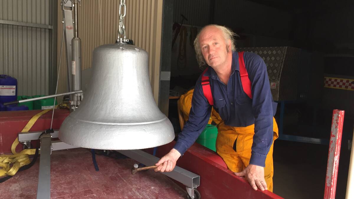 Solemn tool: Mick McLaughlin with the early 1900s fire bell which he has refurbished for use in 50th anniversary commemorations for the Southern Aurora rail tragedy. He is holding a hammer demonstrating how the bell will be struck