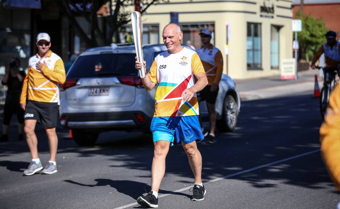 On the road: Dean Woods carries the Queen's baton through Wangaratta to mark the Gold Coast Commonwealth Games in 2018.