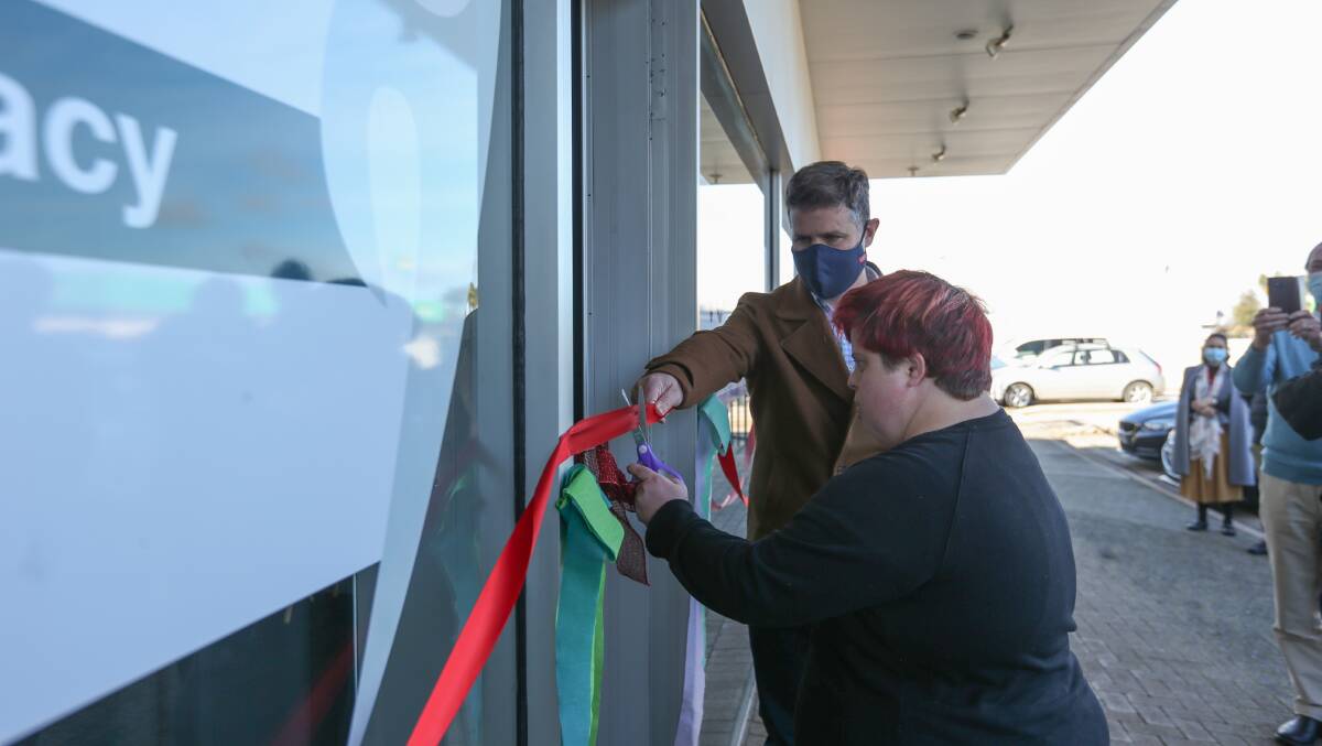 Cutting edge: Tara Hills cuts the ribbon to open the new disability service office as member for Albury Justin Clancy holds the material. Picture: TARA TREWHELLA