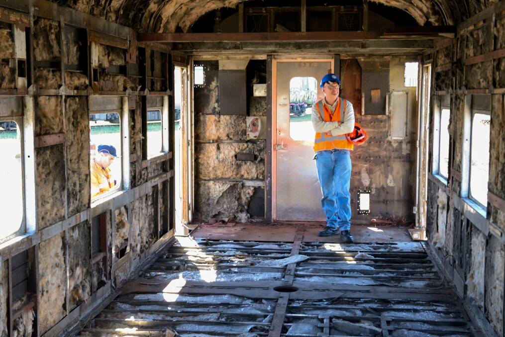 Rundown: Bruce Cumming's brother Doug inside the carriage bound for Violet Town. Despite the exposed insulation it has been cleared of asbestos concerns.