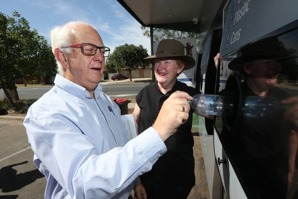 Plastic not fantastic: Bob Mathews puts a bottle in the reverse vending machine at Springdale Heights while being watched by NSW Small Business Commissioner Robyn Hobbs on a hot Tuesday morning. Picture: KYLIE ESLER
