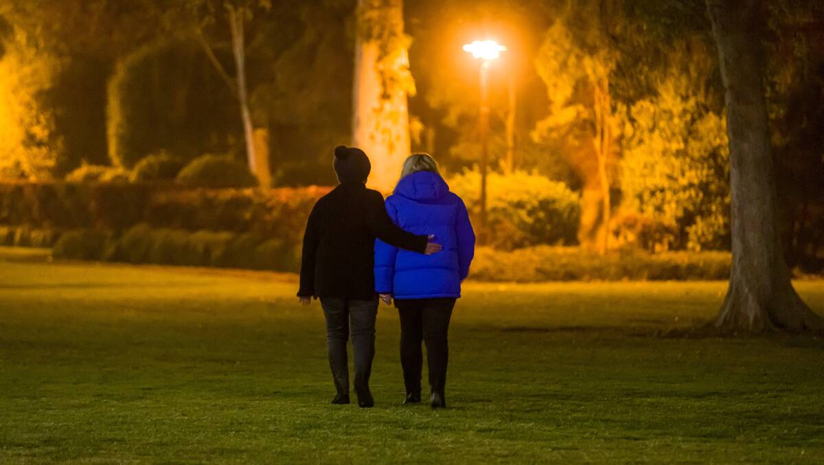 Comforting hand: A still from the film showing two people at this year's Winter Solstice gathering in Albury.