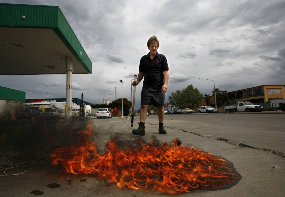 FLASHBACK: Steve Bowdren in 2008 demonstrates dangers of fuel seeping beyond tanks with fire on the apron of the then BP petrol station on the corner of Young and Guinea streets in Albury.