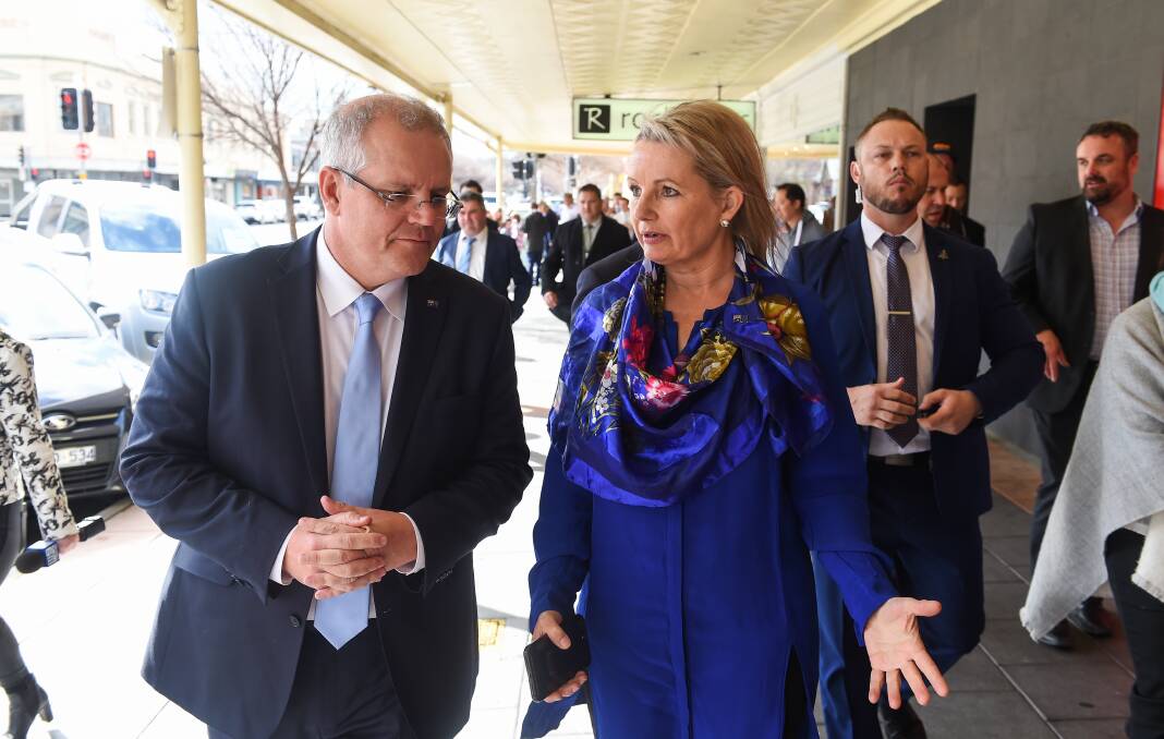 Sharing a thought: Prime Minister Scott Morrison listens as Sussan Ley chats to him during a walk along Kiewa Street on Thursday.