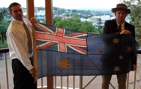 Piece of history: Lochlan Maughan and Nigel Morris with the flag which has ties to World War II and the conflict on Tarakan in 1945.