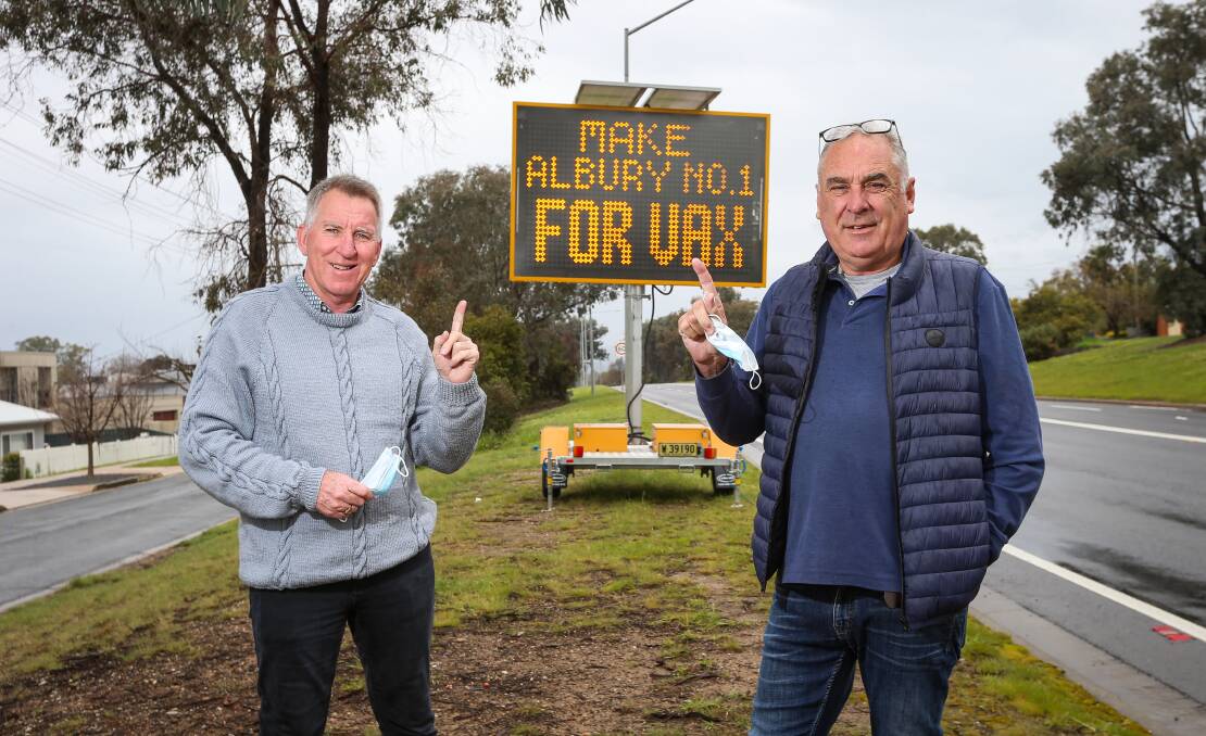 Doing their bit: Albury mayor Kevin Mack and councillor Murray King in front of a mobile board urging their citizens to get vaccinated. Picture: JAMES WILTSHIRE